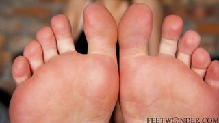 She takes her stinky socks and sneakers and shows her soles