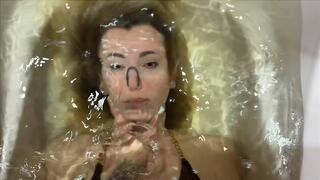 Girl holds Helga underwater and plays with her hair