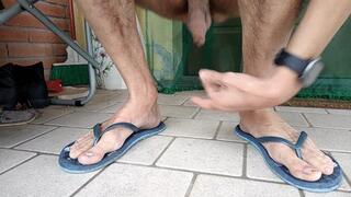 Male feet dangling and heelpopping flip flops and sandals